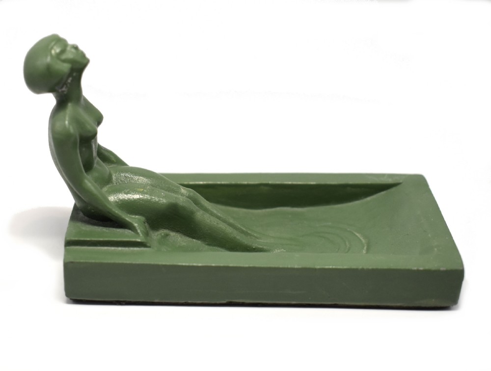 A green Art Deco spelter pin dish featuring a reclining female figure resting along the edge of a small rectangular tray. View VIII