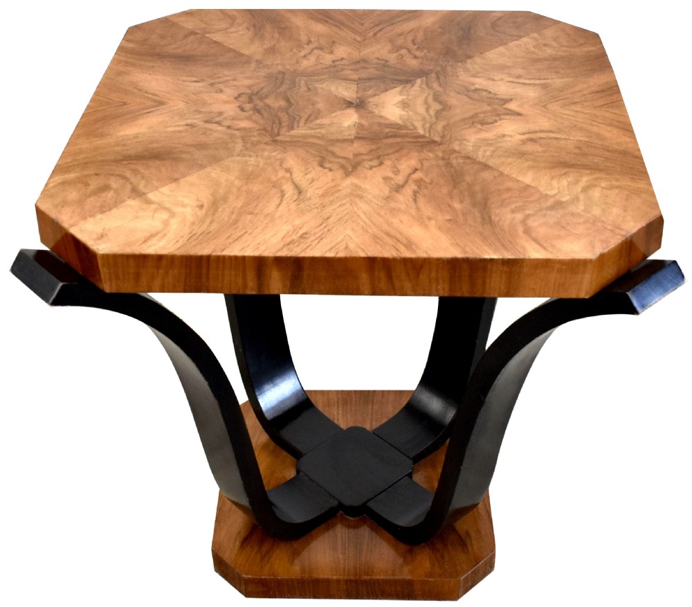 An Art Deco occasional table featuring an octagonal walnut veneer top supported by four curved ebonised legs resting on an octagonal base.