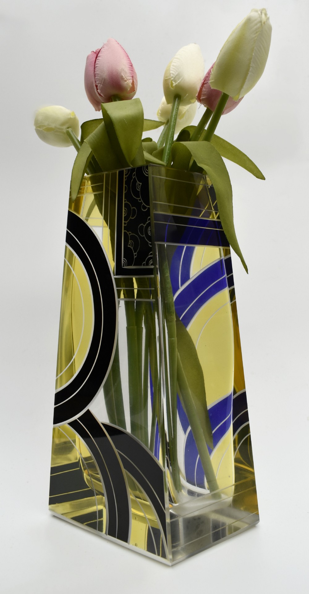 A tall tapered rectangular clear glass vase decorated with black enamel arcs, yellow panels, and etched geometric patterns. View III