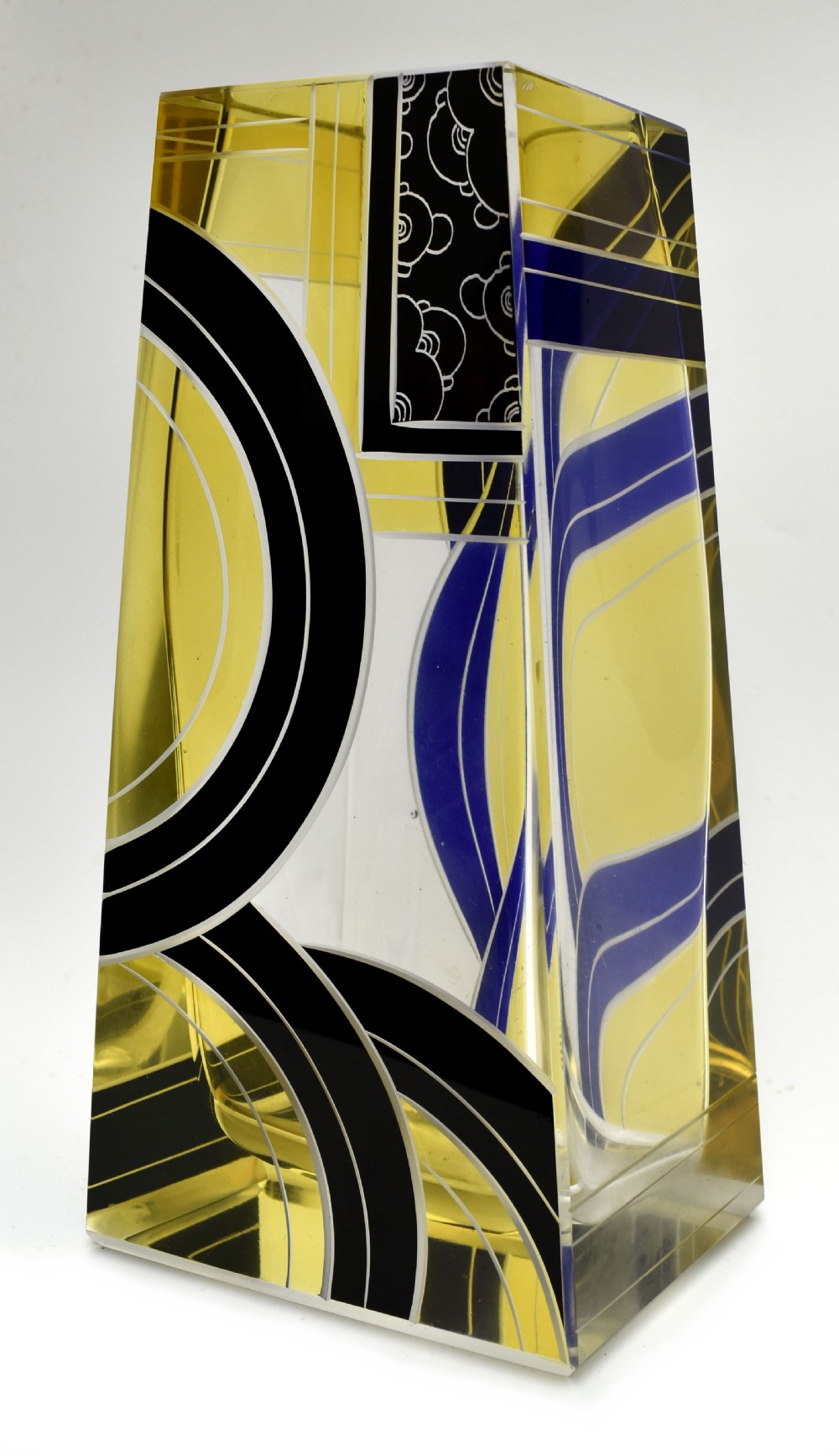 A tall tapered rectangular clear glass vase decorated with black enamel arcs, yellow panels, and etched geometric patterns. View VI