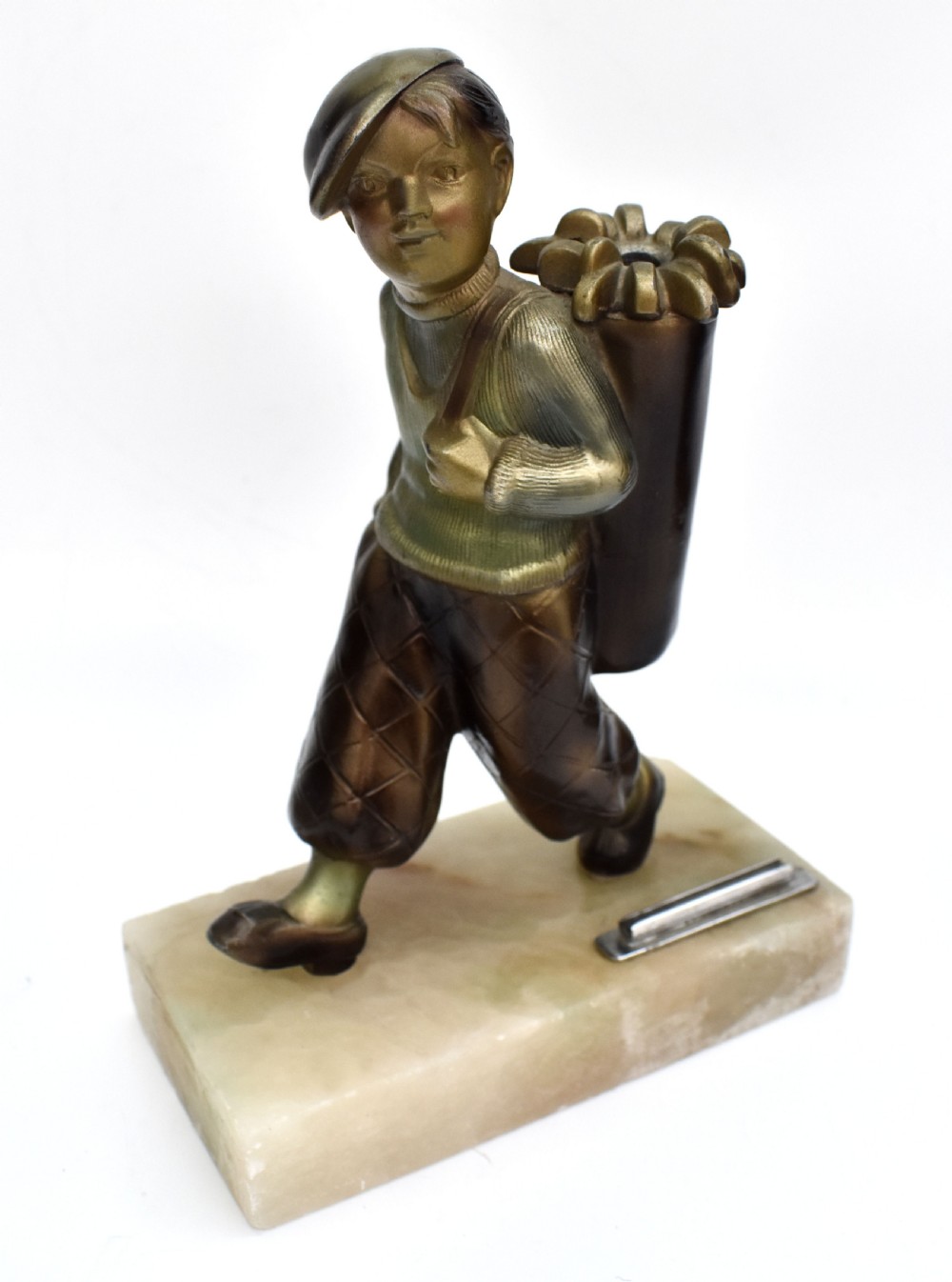 An Art Deco cold-painted bronze sculpture of a golf caddy carrying a bag, mounted on a rectangular cream onyx base with an attached metal lighter striker. View VIII