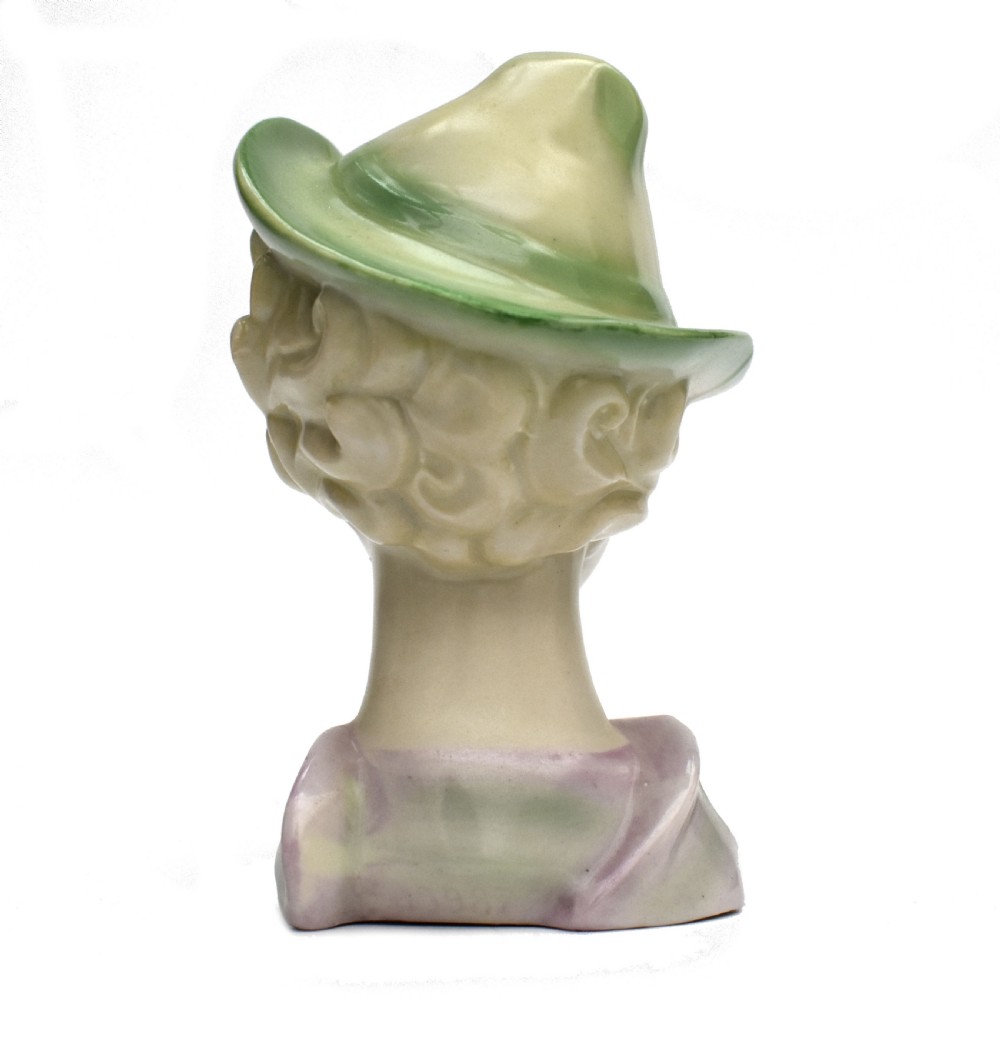 An Art Deco ceramic bust of a lady wearing a pale green hat and a floral corsage on a plain white background. View IV