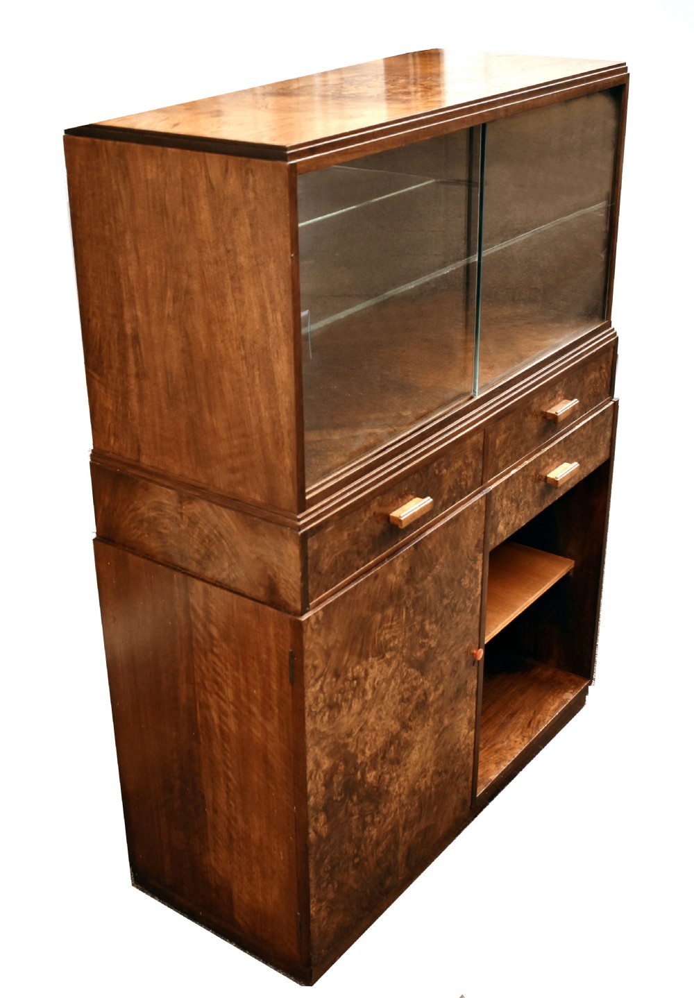 An Art Deco figured walnut drinks cabinet featuring a glass-fronted upper display section with glass shelves, drawers, and lower storage compartments. View VIII