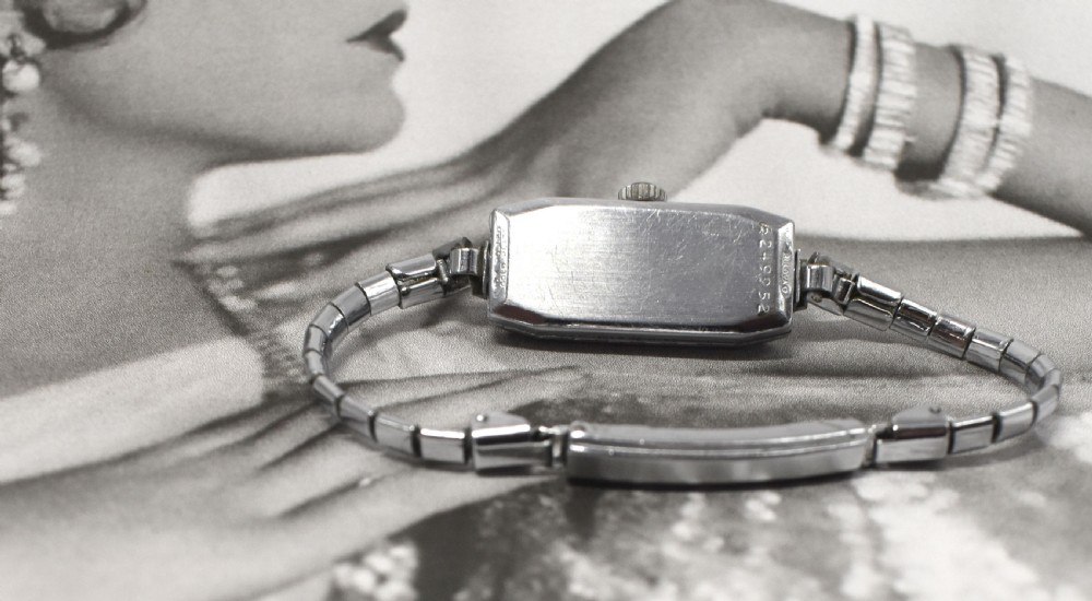 An Art Deco Bulova ladies bracelet watch from 1935 featuring a narrow rectangular silver-coloured case with geometric lugs and an articulated chain strap. View V