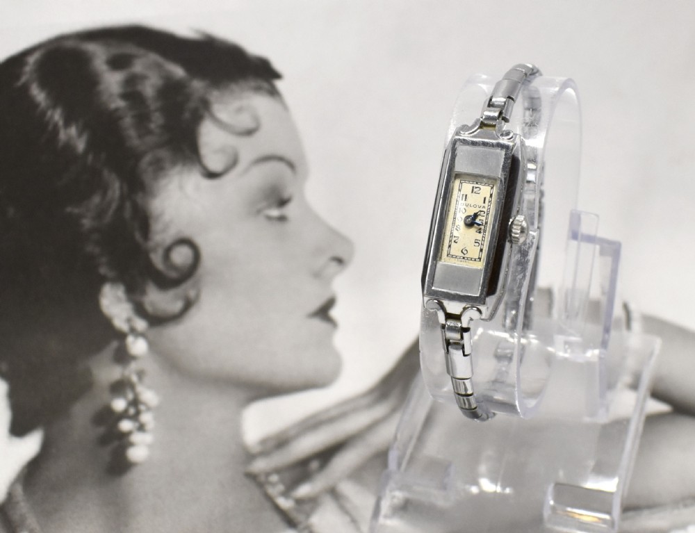 An Art Deco Bulova ladies bracelet watch from 1935 featuring a narrow rectangular silver-coloured case with geometric lugs and an articulated chain strap. View VII