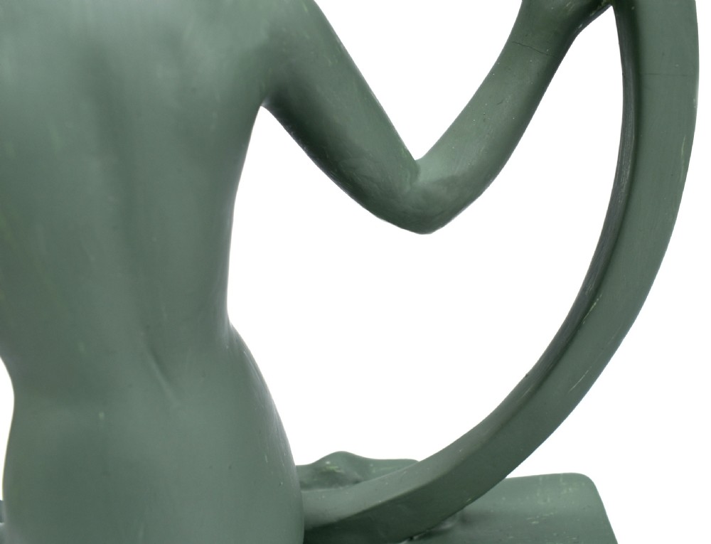 A sage green Art Deco painted plaster figurine depicting a kneeling female figure inside a circular hoop set on a rectangular base. View VI