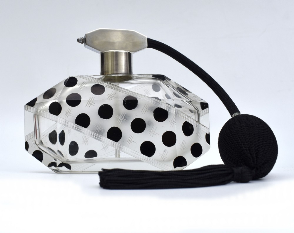 An Art Deco faceted clear glass perfume atomizer featuring black enamel polka dots, crosshatch etchings, a silver-toned metal mount, and a black fabric squeeze bulb with a tassel. View II