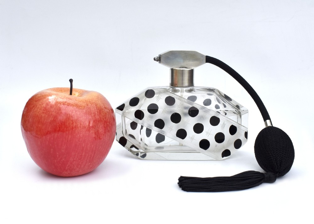 An Art Deco faceted clear glass perfume atomizer featuring black enamel polka dots, crosshatch etchings, a silver-toned metal mount, and a black fabric squeeze bulb with a tassel. View III