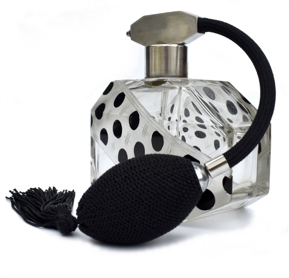 An Art Deco faceted clear glass perfume atomizer featuring black enamel polka dots, crosshatch etchings, a silver-toned metal mount, and a black fabric squeeze bulb with a tassel. View V