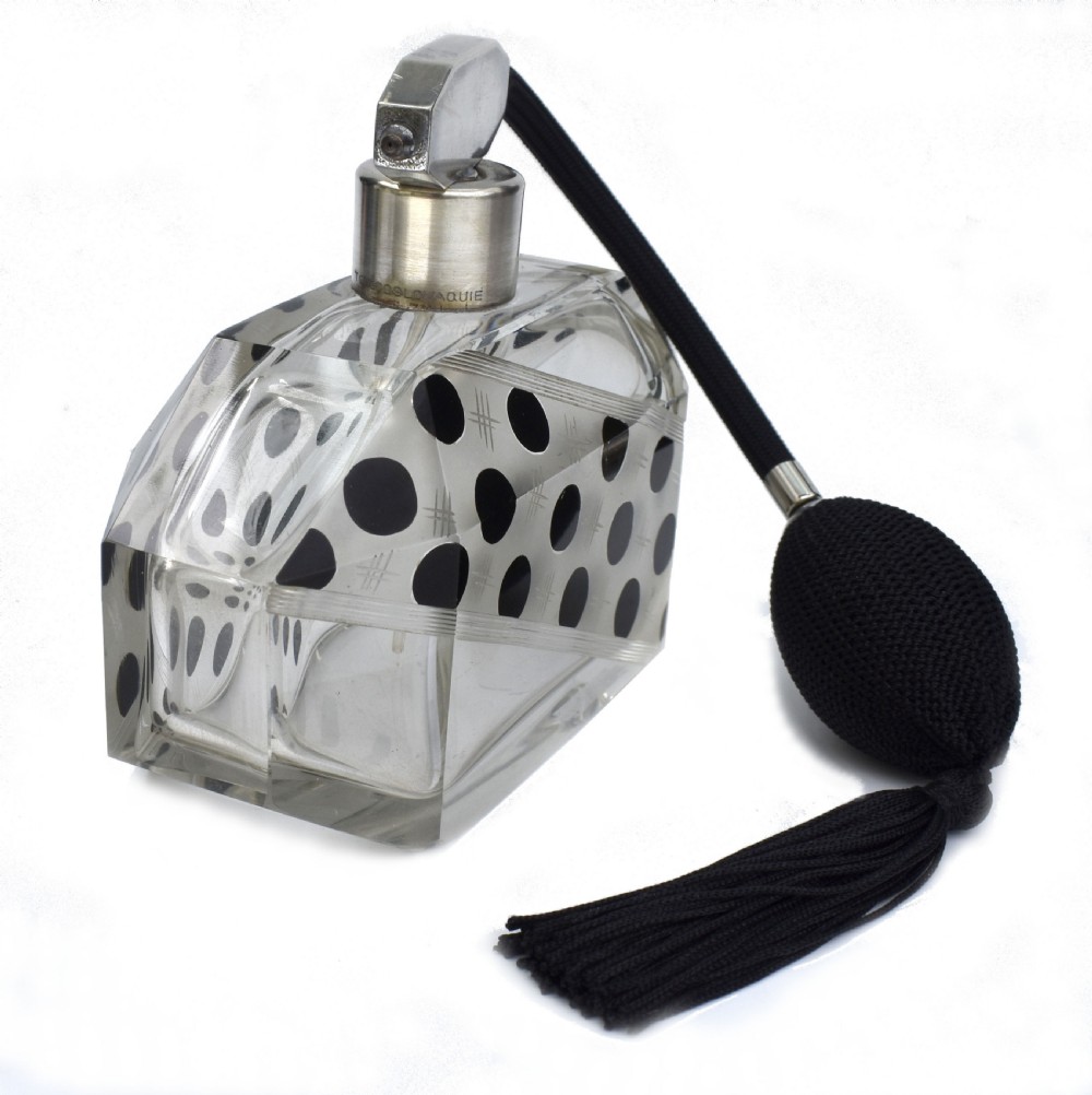 An Art Deco faceted clear glass perfume atomizer featuring black enamel polka dots, crosshatch etchings, a silver-toned metal mount, and a black fabric squeeze bulb with a tassel. View VI