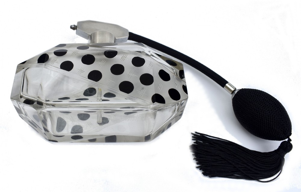 An Art Deco faceted clear glass perfume atomizer featuring black enamel polka dots, crosshatch etchings, a silver-toned metal mount, and a black fabric squeeze bulb with a tassel. View VII