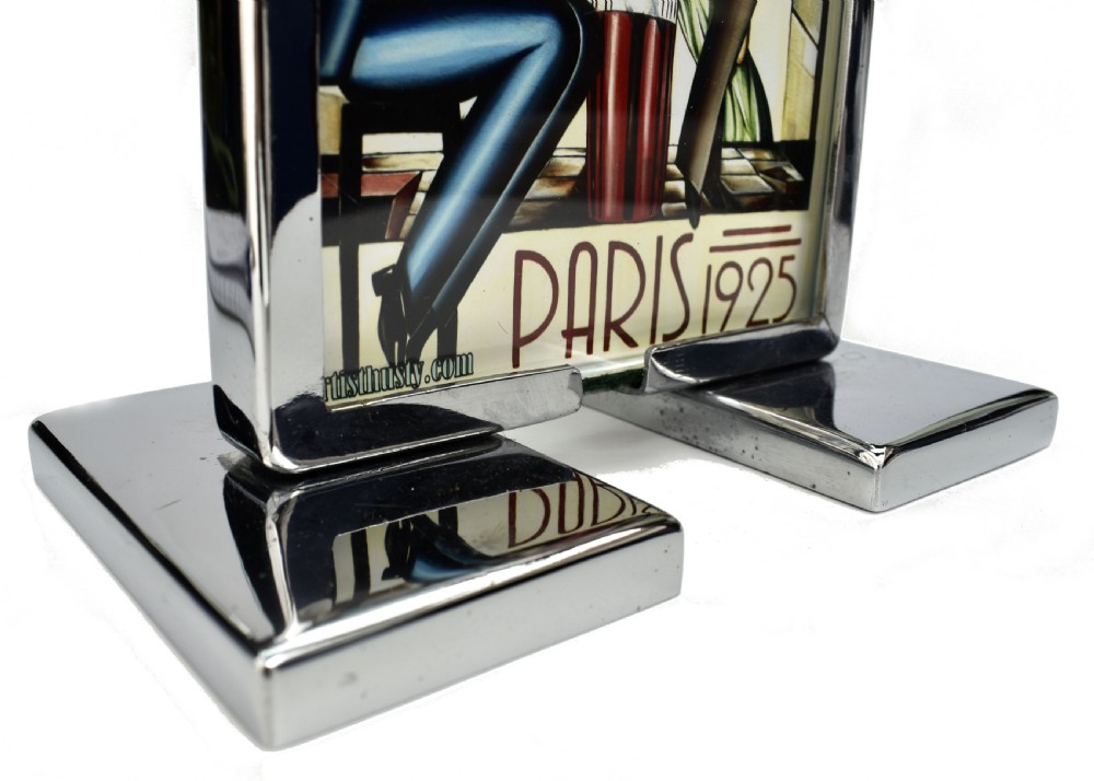 An Art Deco chrome and glass free-standing picture frame featuring a stepped metal base holding a black and white portrait photo. View VI