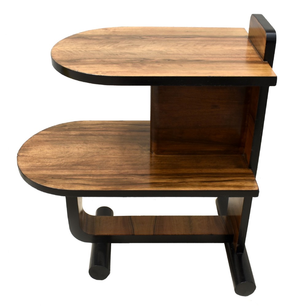 A two-tier Art Deco modernist walnut side table featuring curved cantilevered shelves, ebonised trim, and cylindrical base supports. View II