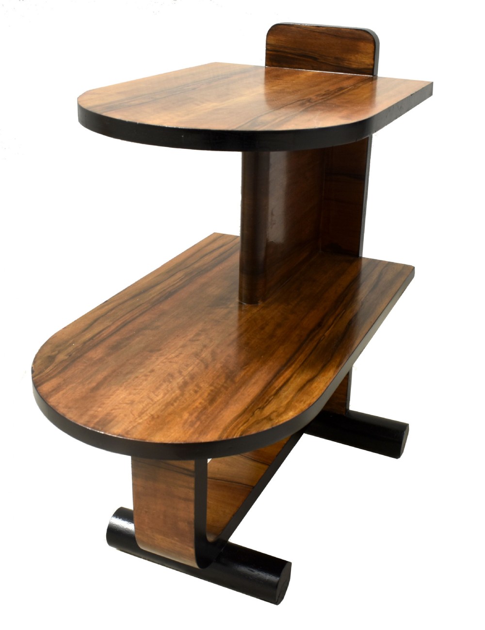 A two-tier Art Deco modernist walnut side table featuring curved cantilevered shelves, ebonised trim, and cylindrical base supports. View III