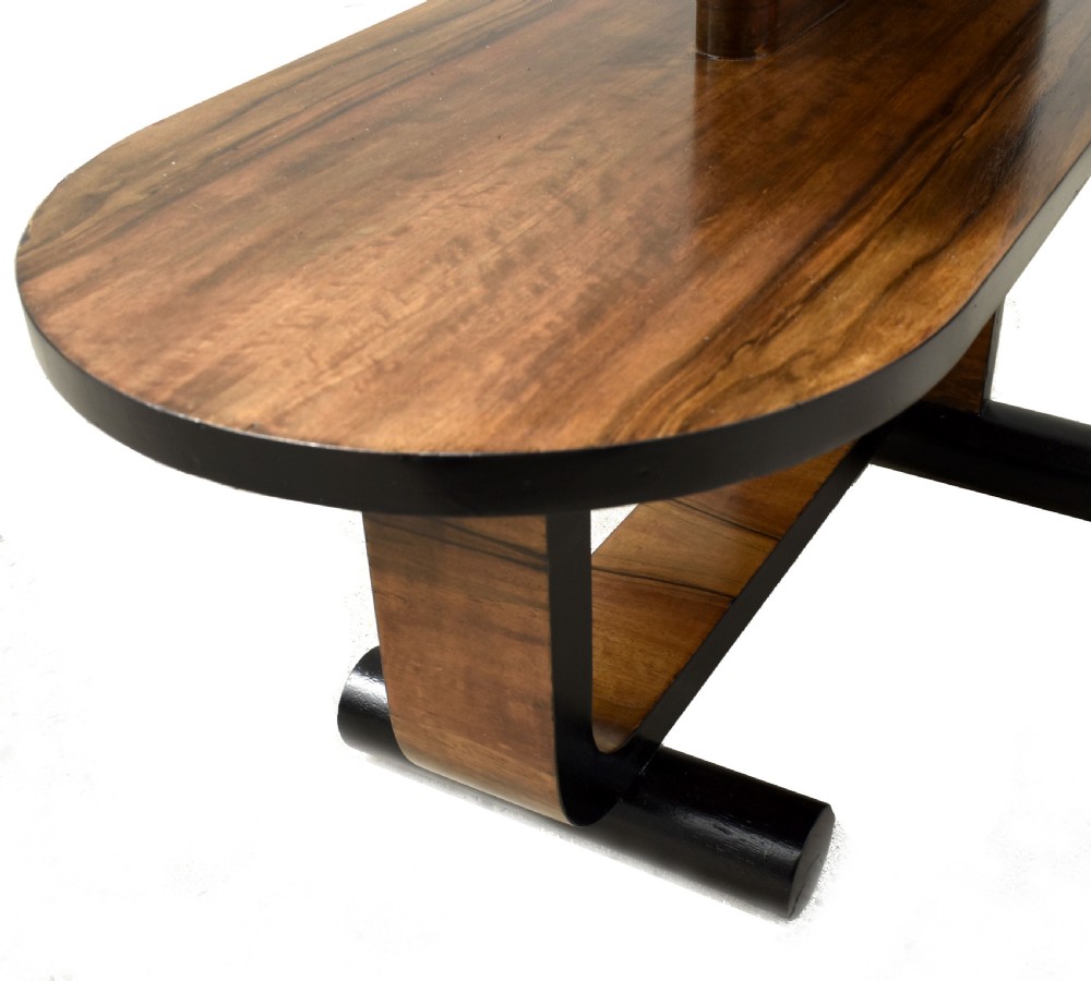 A two-tier Art Deco modernist walnut side table featuring curved cantilevered shelves, ebonised trim, and cylindrical base supports. View V