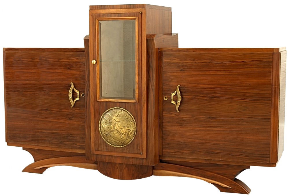 A French Art Deco walnut sideboard featuring a raised central glass vitrine above an embossed brass medallion, flanked by two veneered cupboard doors on an arched base. View III