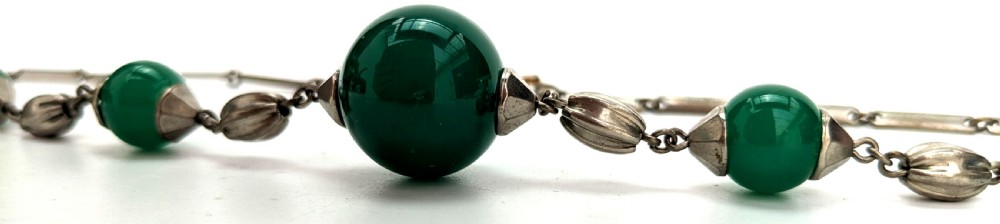 An Art Deco necklace featuring deep green glass spherical beads fitted with fluted metal caps and connected by elongated metal bar links. View III