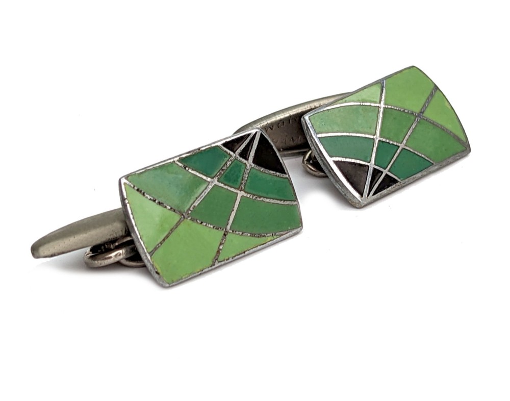A matching pair of rectangular Art Deco cufflinks featuring segmented green and black enamel in a geometric pattern set in silver-toned metal.