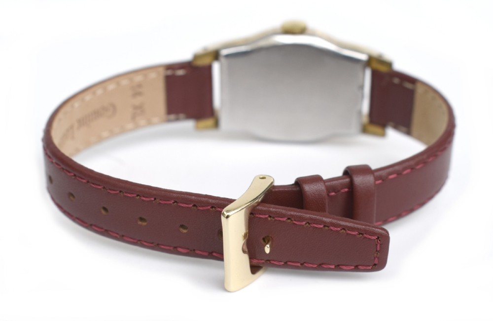 An Art Deco Bulova gents wristwatch featuring a gold-tone tonneau case with engraved side detailing, a cream dial with gold numerals, and a burgundy leather strap. View VI