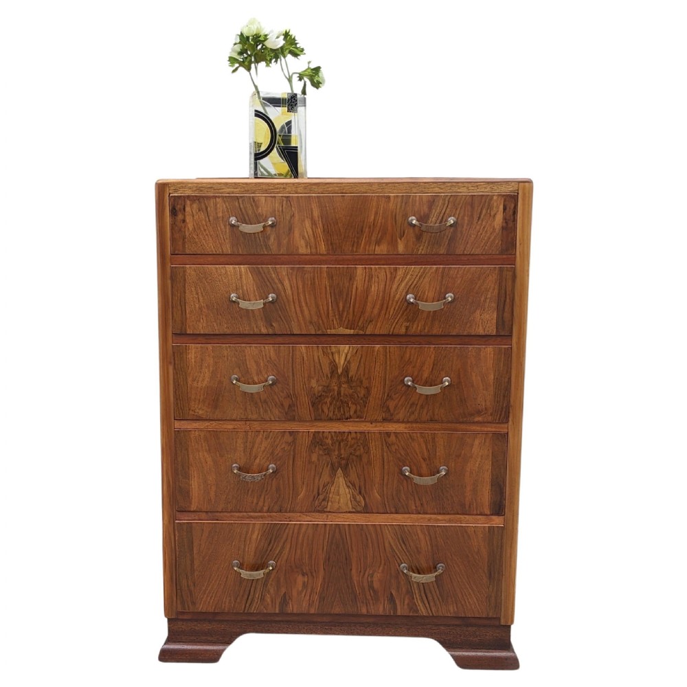 An Art Deco walnut chest featuring five graduated drawers with bookmatched wood grain and curved brass handles. View III