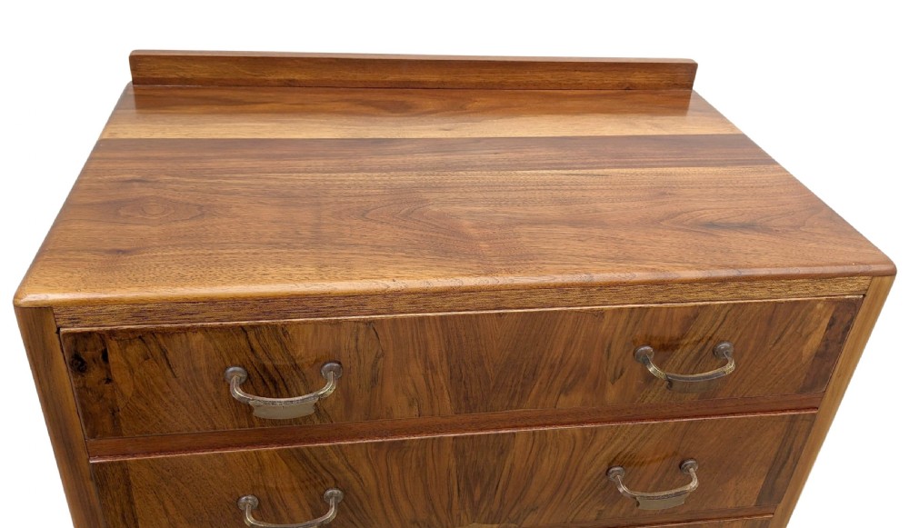 An Art Deco walnut chest featuring five graduated drawers with bookmatched wood grain and curved brass handles. View VI