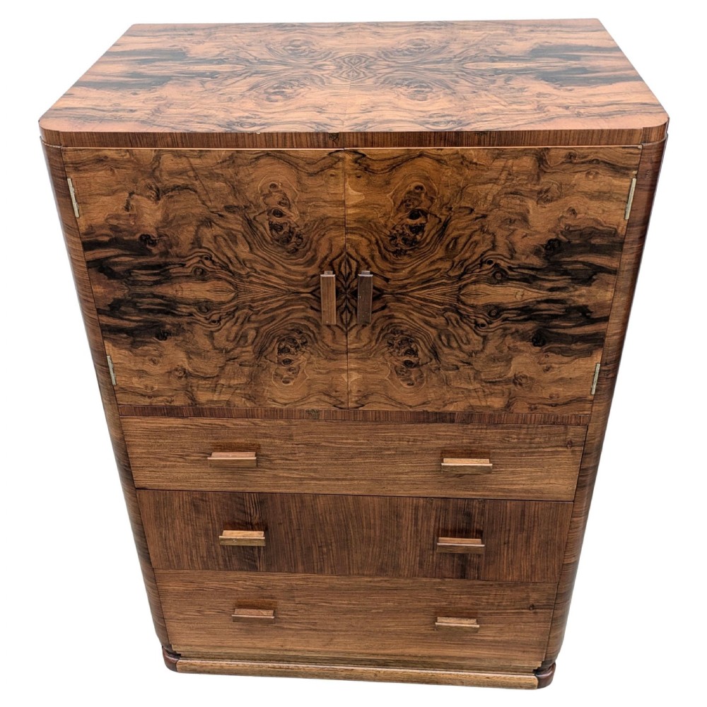 An English Art Deco tallboy crafted from figured burr walnut, featuring a top two-door cupboard above three full-width drawers with matching handles. View II