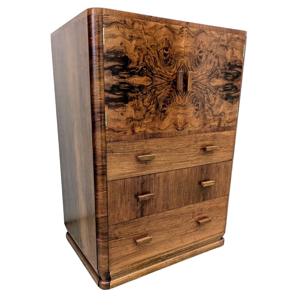 An English Art Deco tallboy crafted from figured burr walnut, featuring a top two-door cupboard above three full-width drawers with matching handles. View III