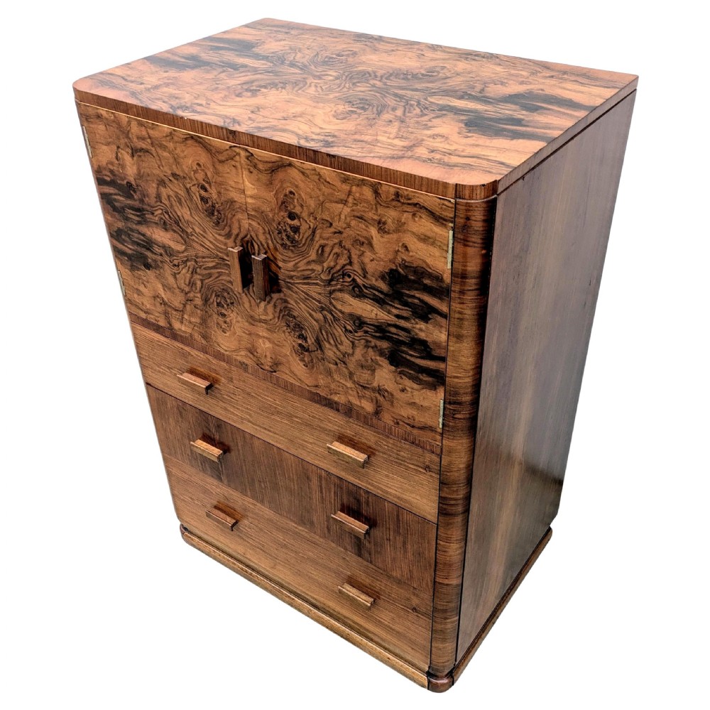 An English Art Deco tallboy crafted from figured burr walnut, featuring a top two-door cupboard above three full-width drawers with matching handles. View IV