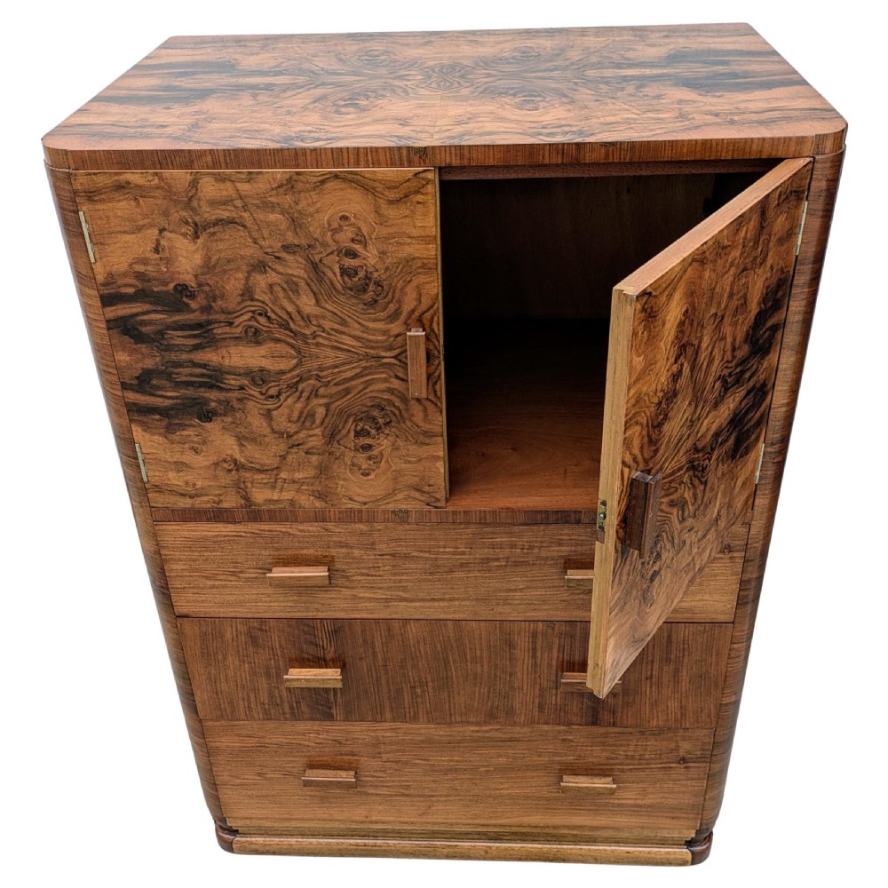 An English Art Deco tallboy crafted from figured burr walnut, featuring a top two-door cupboard above three full-width drawers with matching handles. View XIII