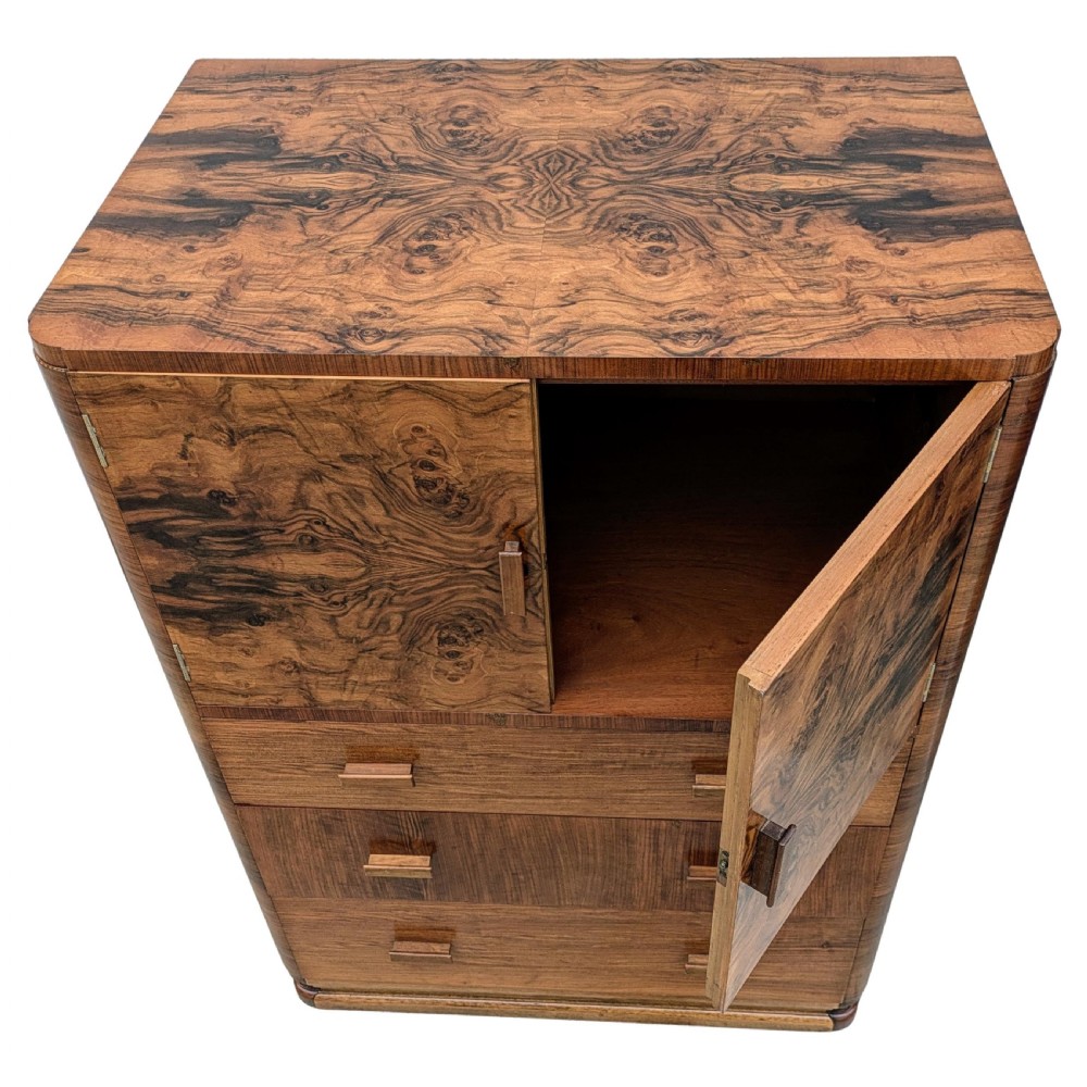 An English Art Deco tallboy crafted from figured burr walnut, featuring a top two-door cupboard above three full-width drawers with matching handles. View XIV