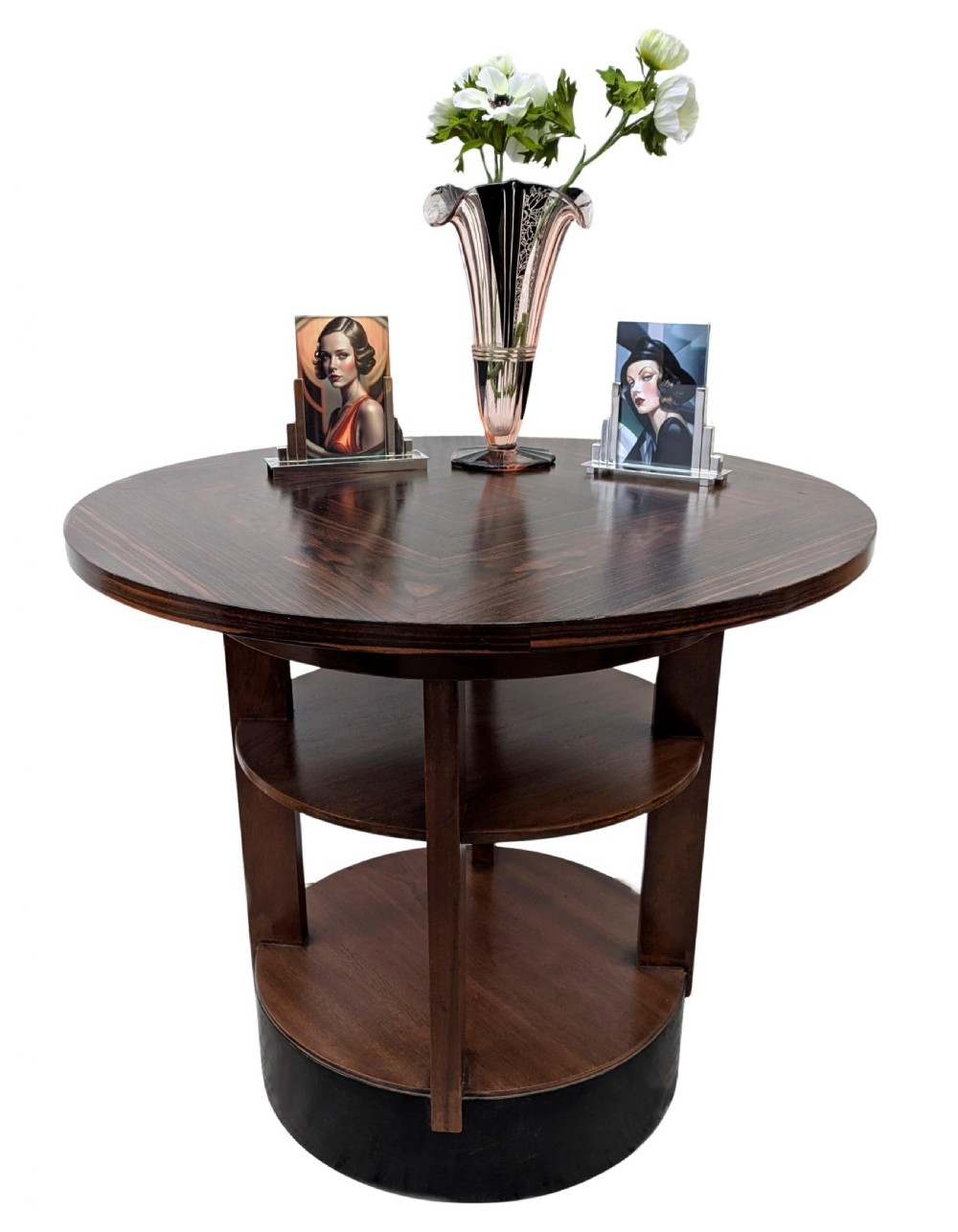 An Art Deco circular dark wood centre table featuring three tiered shelves supported by four vertical legs resting on a solid round base.