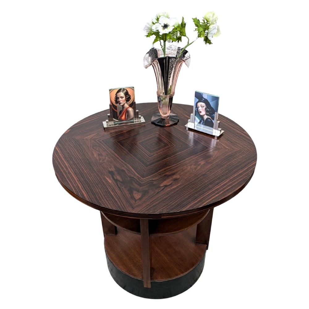 An Art Deco circular dark wood centre table featuring three tiered shelves supported by four vertical legs resting on a solid round base. View III