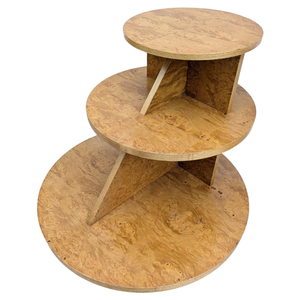 A matching pair of British Art Deco three-tiered modernist occasional tables featuring figured light brown wood veneer and architectural angular supports. View III