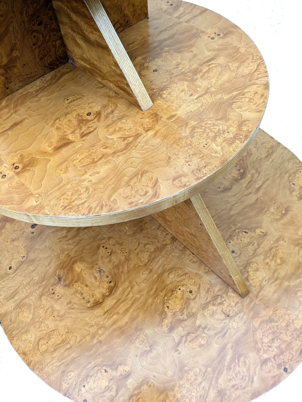 A matching pair of British Art Deco three-tiered modernist occasional tables featuring figured light brown wood veneer and architectural angular supports. View IV