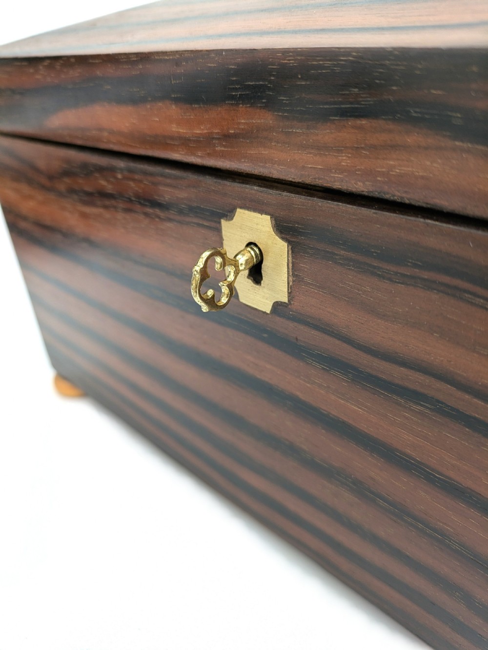 An open Art Deco dark wood tea caddy featuring a light wood sunburst inlay pattern on its internal lid. View VIII