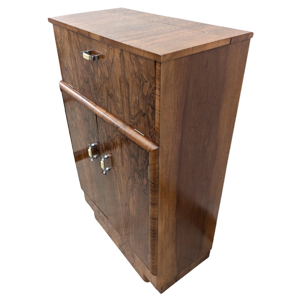 An Art Deco walnut cocktail cabinet featuring an upper pop-up section with integrated bar accessories and a mirrored drop-front serving shelf above double cupboard doors. View IV