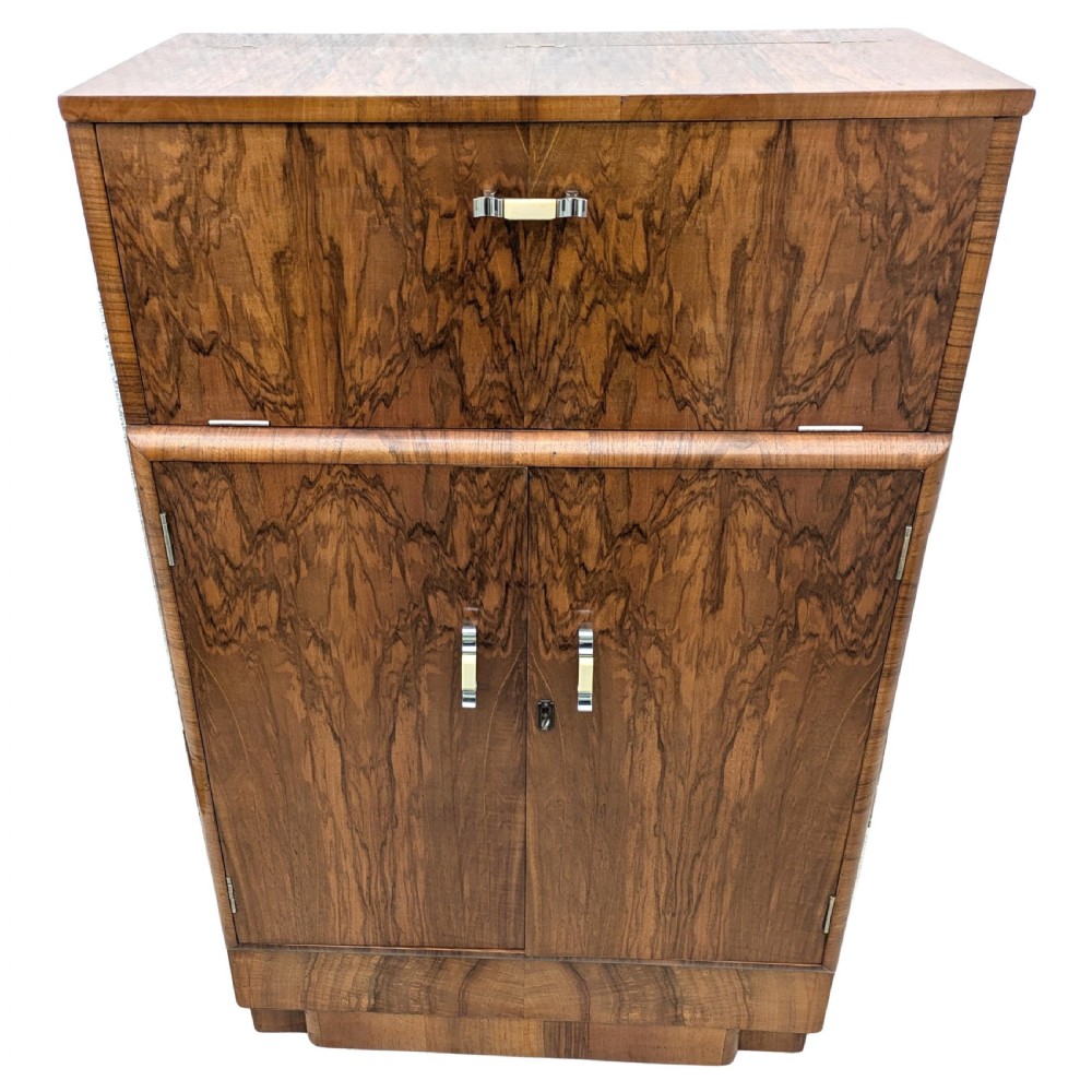 An Art Deco walnut cocktail cabinet featuring an upper pop-up section with integrated bar accessories and a mirrored drop-front serving shelf above double cupboard doors. View V