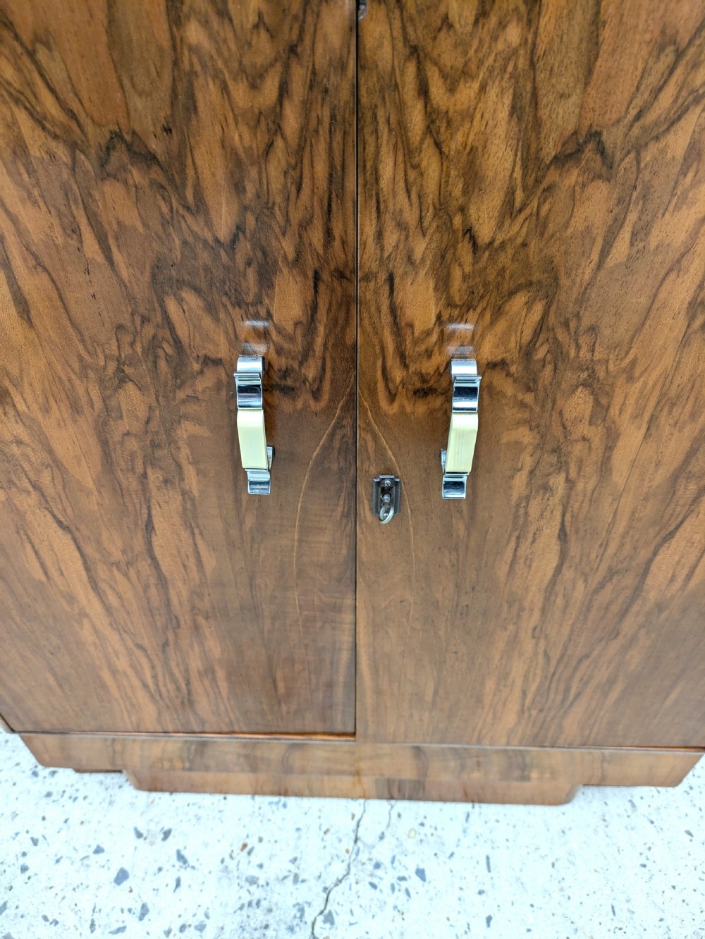 An Art Deco walnut cocktail cabinet featuring an upper pop-up section with integrated bar accessories and a mirrored drop-front serving shelf above double cupboard doors. View VI