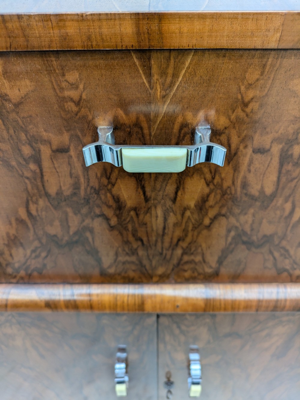 An Art Deco walnut cocktail cabinet featuring an upper pop-up section with integrated bar accessories and a mirrored drop-front serving shelf above double cupboard doors. View VII