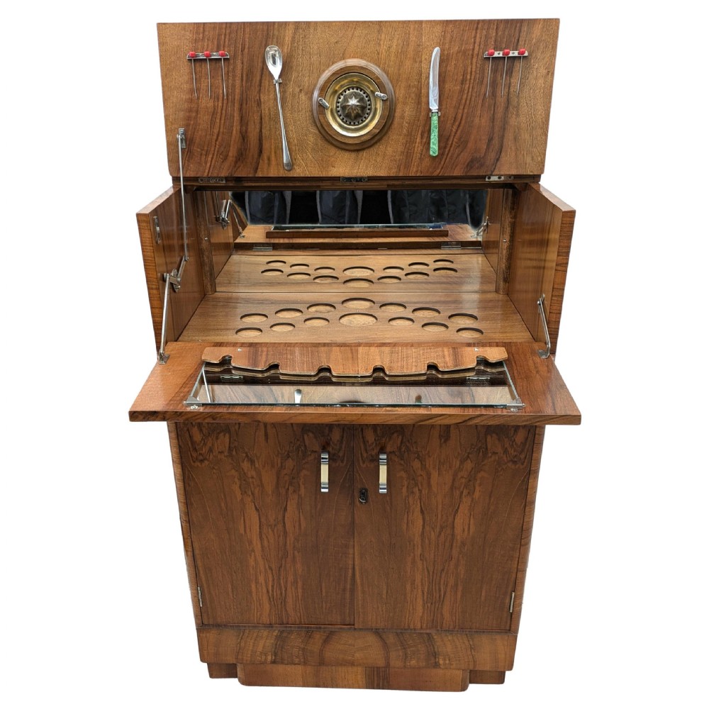 An Art Deco walnut cocktail cabinet featuring an upper pop-up section with integrated bar accessories and a mirrored drop-front serving shelf above double cupboard doors. View IX
