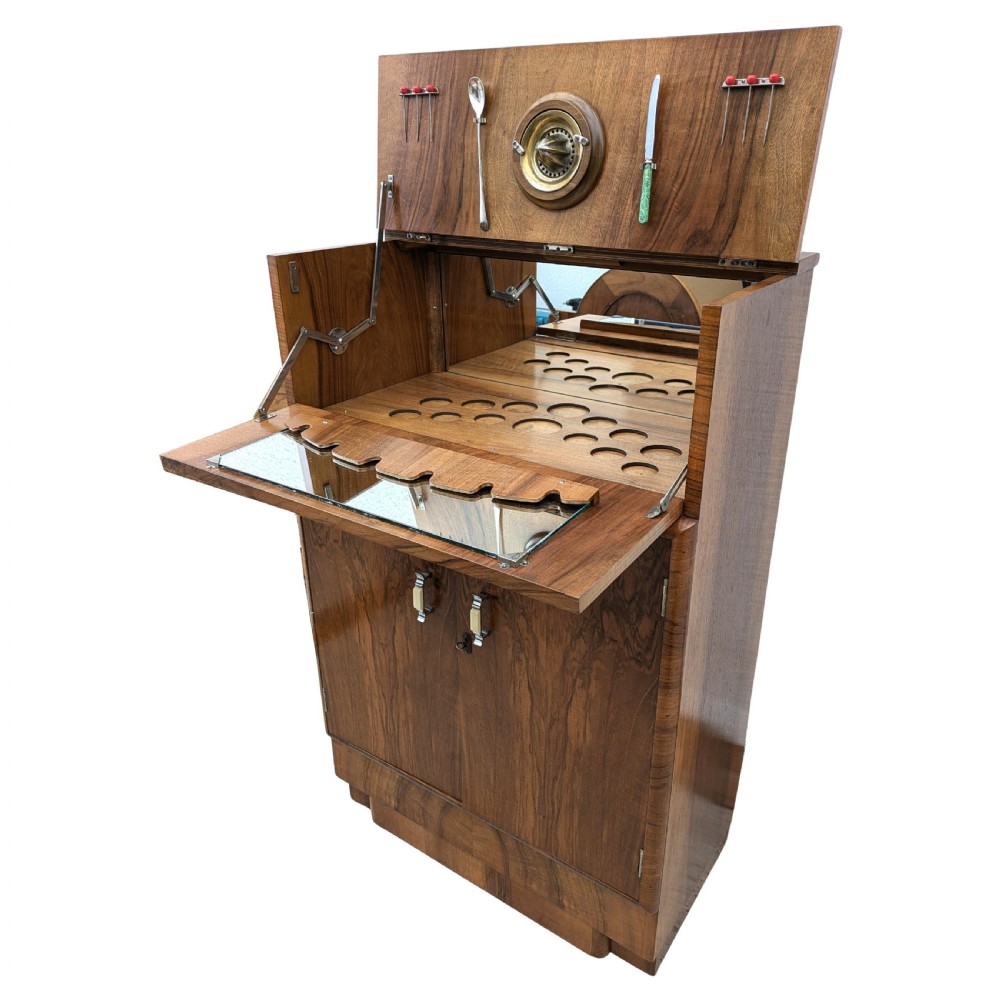 An Art Deco walnut cocktail cabinet featuring an upper pop-up section with integrated bar accessories and a mirrored drop-front serving shelf above double cupboard doors. View X