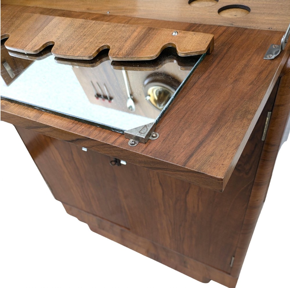 An Art Deco walnut cocktail cabinet featuring an upper pop-up section with integrated bar accessories and a mirrored drop-front serving shelf above double cupboard doors. View XI