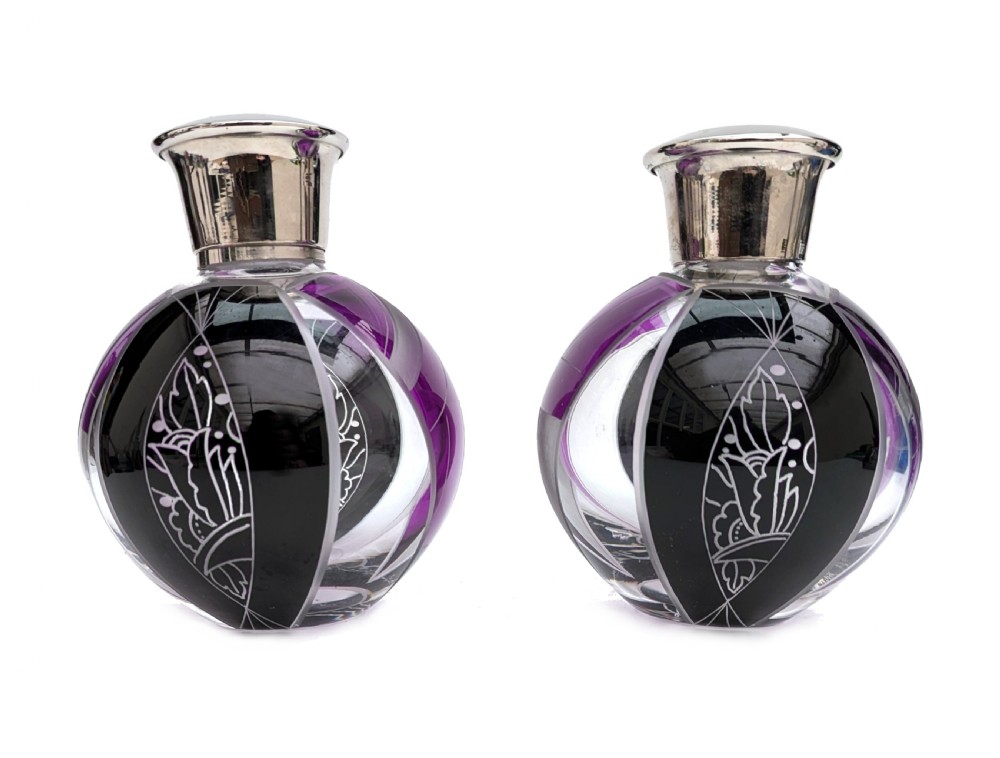 A pair of spherical glass Art Deco perfume bottles featuring purple and black geometric enamel panels with etched floral patterns and polished metal caps. View II