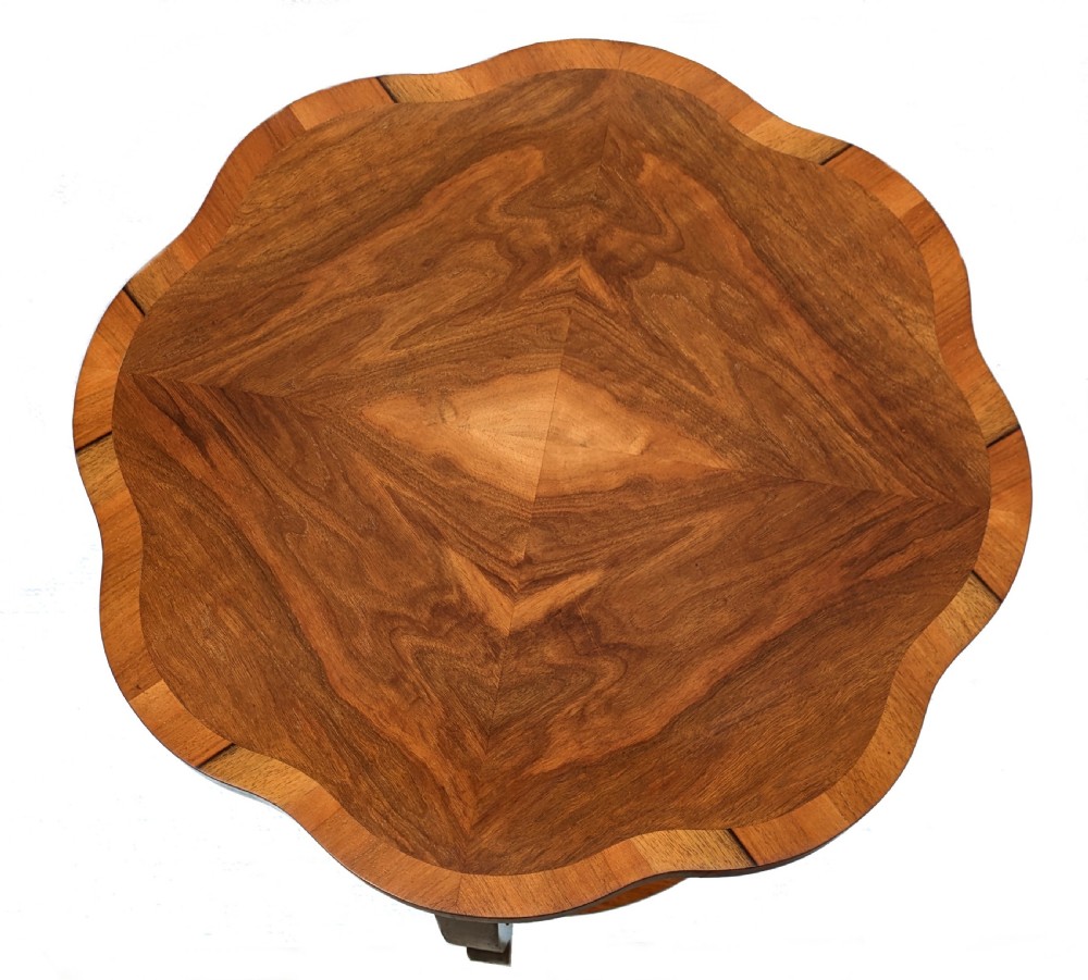 An Art Deco two-tier coffee table in figured walnut with a scalloped top, crossbanded border, circular lower shelf, and curved legs. View II