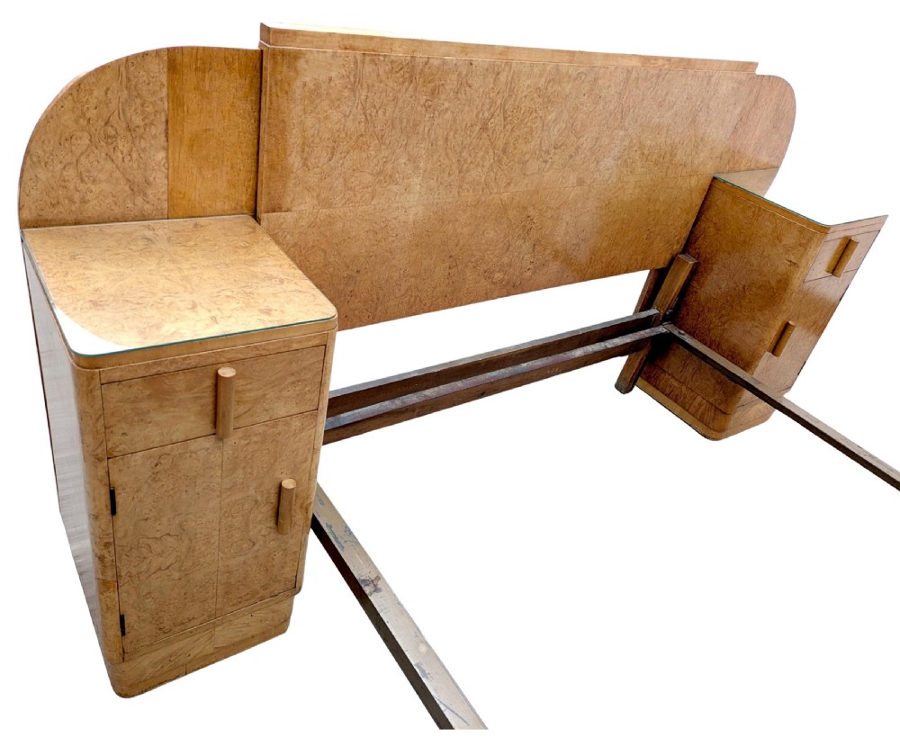 A 1930s Art Deco double bedstead crafted from blonde maple veneer featuring an arched headboard with integrated bedside cabinets and a matching stepped footboard. View V