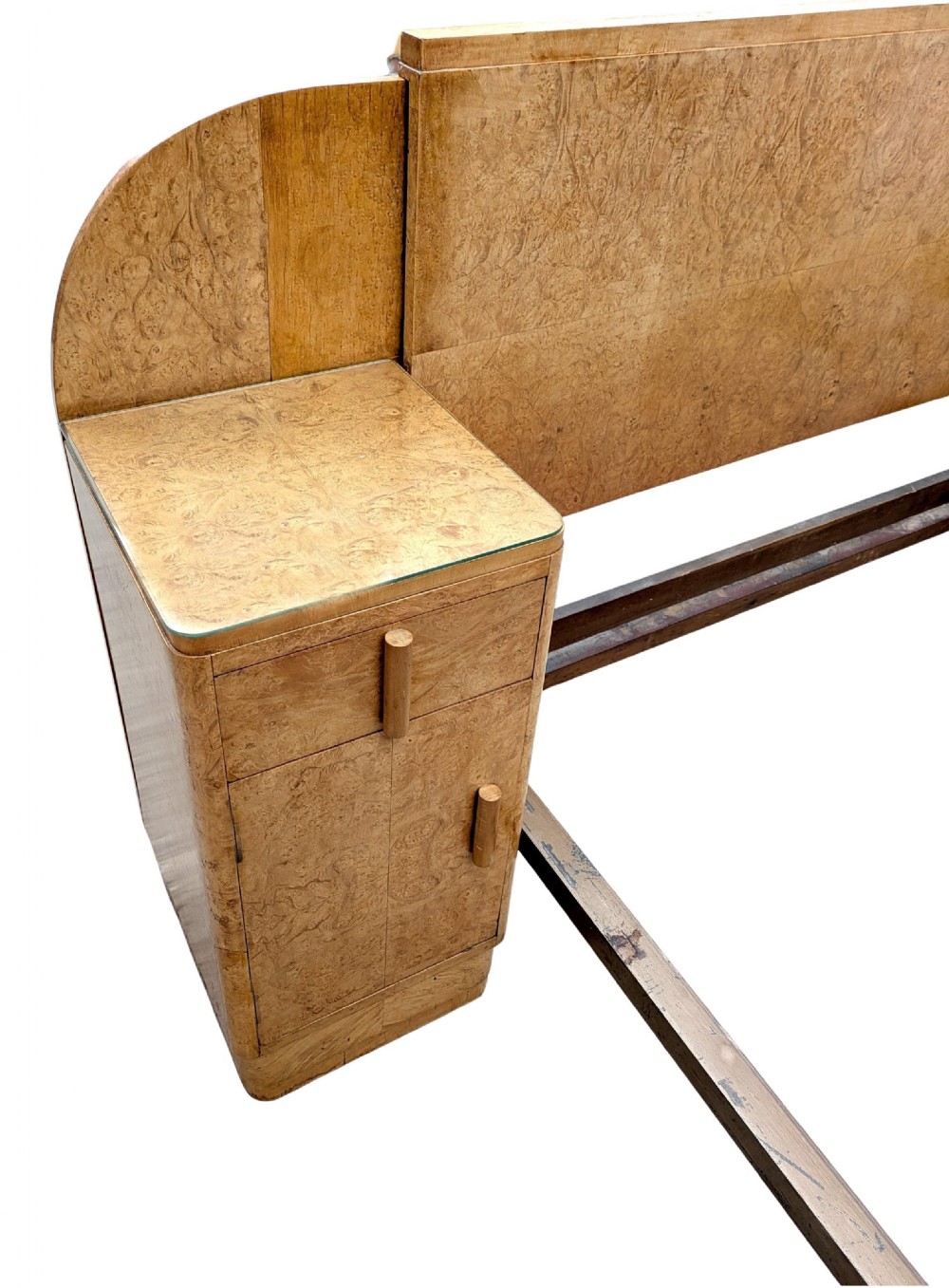 A 1930s Art Deco double bedstead crafted from blonde maple veneer featuring an arched headboard with integrated bedside cabinets and a matching stepped footboard. View VI