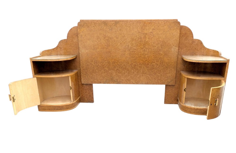 A 1930s Art Deco double bedstead crafted from blonde maple veneer featuring an arched headboard with integrated bedside cabinets and a matching stepped footboard. View VII