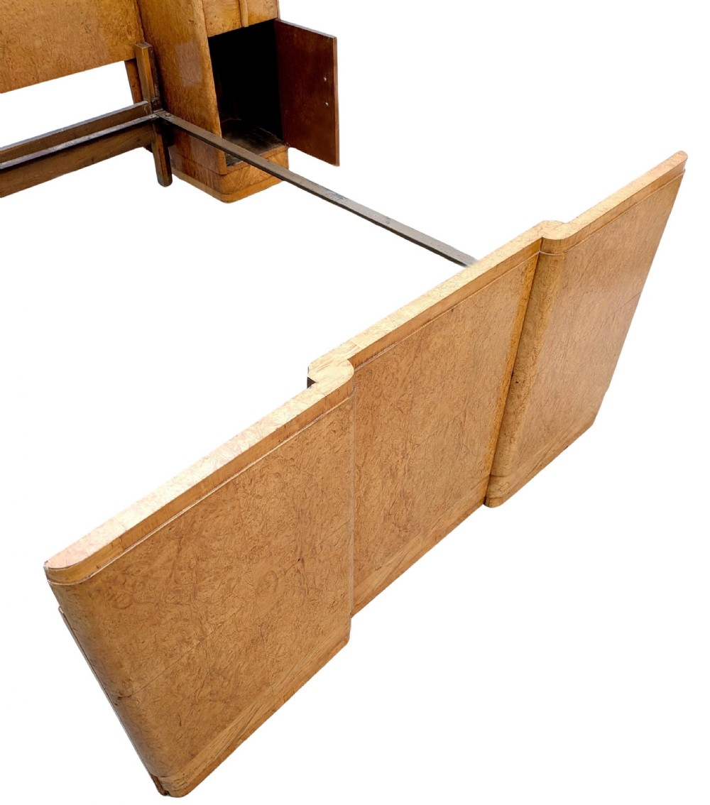A 1930s Art Deco double bedstead crafted from blonde maple veneer featuring an arched headboard with integrated bedside cabinets and a matching stepped footboard. View XI