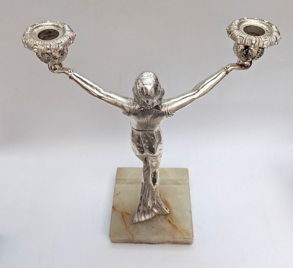 An Art Deco silvered spelter candelabra featuring a female figure holding two candle cups, standing on a square onyx base. View IV