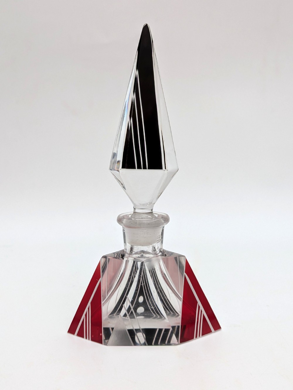 An Art Deco clear and frosted glass perfume bottle featuring a tall faceted stopper and black enamelled geometric designs. View IV
